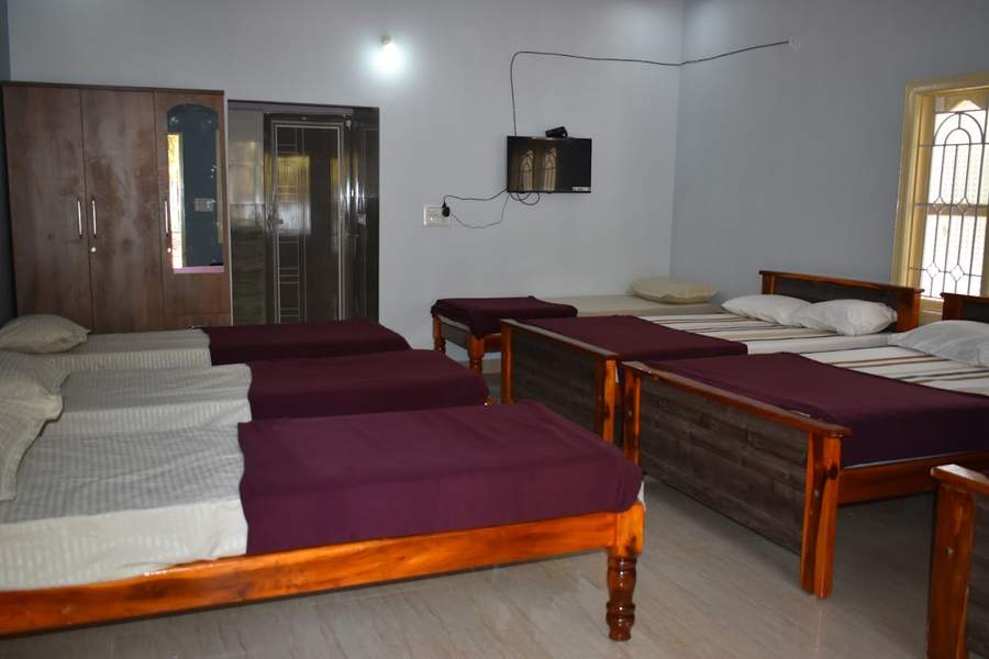 Group dormitory room with multiple beds and TV
