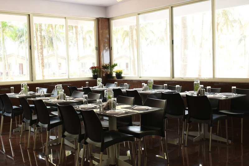 Resort restaurant dining hall with palm garden views